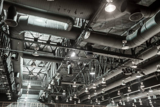 HVAC Duct Cleaning, Ventilation pipes in silver insulation material hanging from the ceiling inside new building. HVAC Duct Cleaning, Ventilation pipes in silver insulation material hanging from the ceiling inside new building. chiller hvac equipment photos stock pictures, royalty-free photos & images