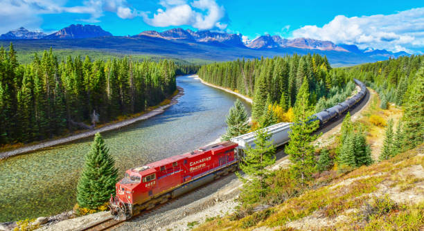 Long freight train moving along Bow river in Canadian Rockies,Canada. Long freight train Canadian Pacific Railway moving along Bow river in Canadian Rockies ,Banff National Park, Canadian Rockies,Canada. canadian rockies stock pictures, royalty-free photos & images