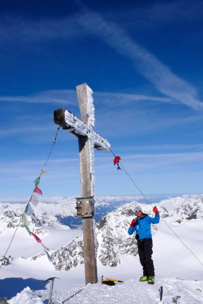 мужской лыжник бэккантри на вершине креста высокогорного пика в прекрасный зимний день - mountain switzerland scuol mountain peak стоковые фото и изображения