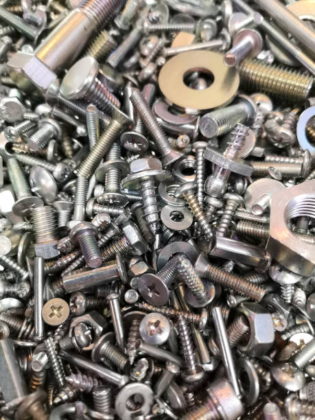 una grande e interessante pila di dadi e bulloni metallici nuovi e lucenti, viti e rondelle. - bolt nut washer threaded foto e immagini stock