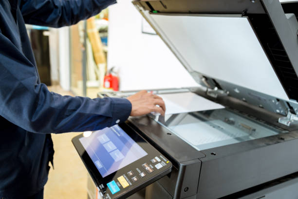 istock Bussiness man Hand press button on panel of printer, printer scanner laser office copy machine supplies start concept. 960462038