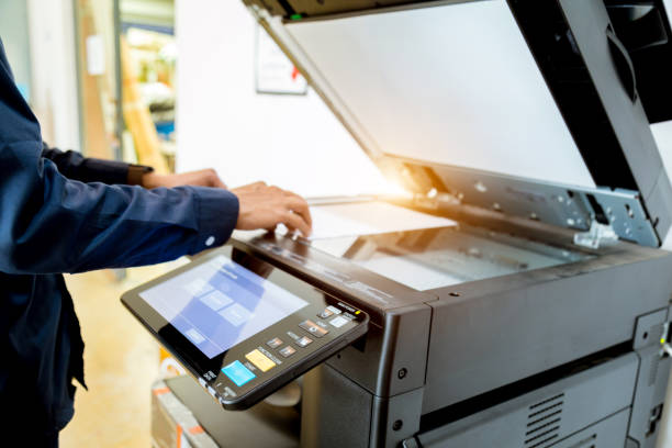istock Bussiness man Hand press button on panel of printer, printer scanner laser office copy machine supplies start concept. 960462056