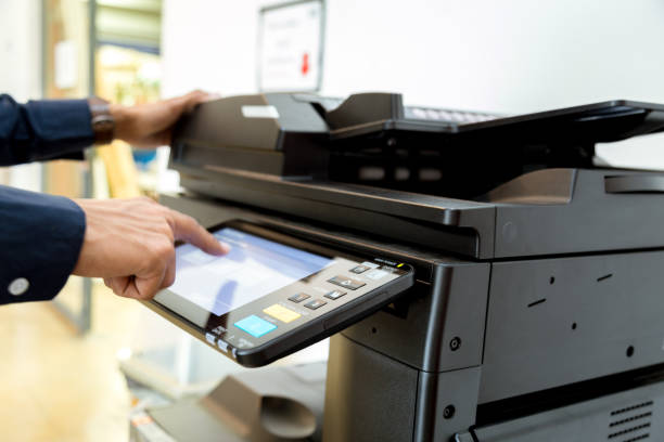 istock Bussiness man Hand press button on panel of printer, printer scanner laser office copy machine supplies start concept. 960462098