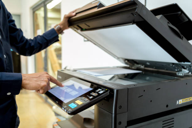 istock Bussiness man Hand press button on panel of printer, printer scanner laser office copy machine supplies start concept. 960462110