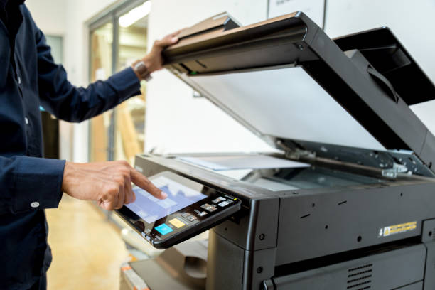 istock Bussiness man Hand press button on panel of printer, printer scanner laser office copy machine supplies start concept. 960462146