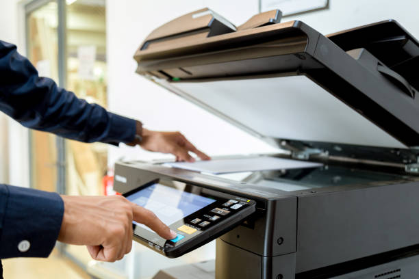 istock Bussiness man Hand press button on panel of printer, printer scanner laser office copy machine supplies start concept. 960462192