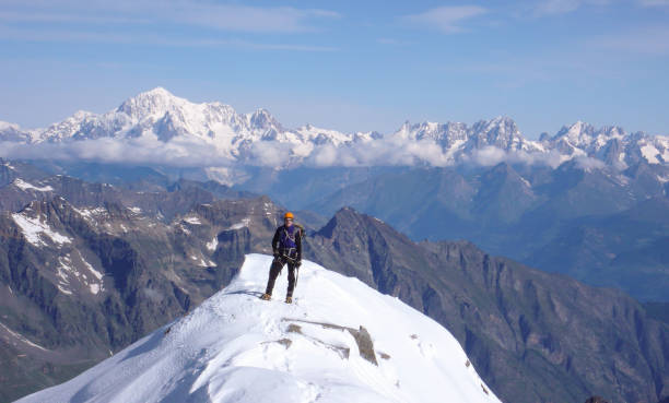 alpinista masculino no cume do gran paradiso com uma bela vista do mont blanc atrás dele - parque nacional de gran paradiso - fotografias e filmes do acervo
