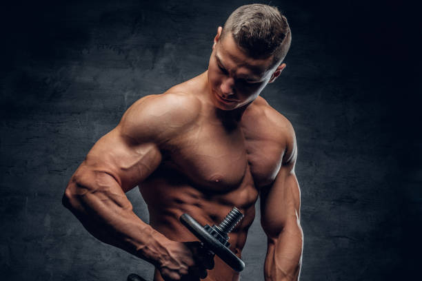 istock Shirtless muscular male doing workouts with one dumbbell. 960466482