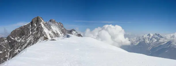 A panorama mountain landscape in the Swiss Alps near Zermatt on a beautiful day in late winter under a blue sky