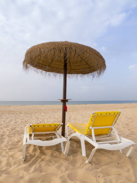 istock Beach scene with sunbeds and straw umbrella. Summer beach vacation concept 960468058