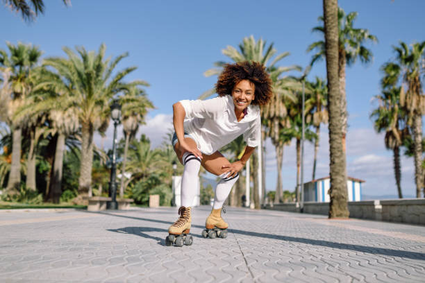 istock Black woman on roller skates rollerblading in beach promenade with palm trees 960469678