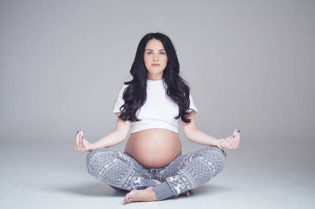 istock Pregnant brunette woman sits on a floor. 960469874