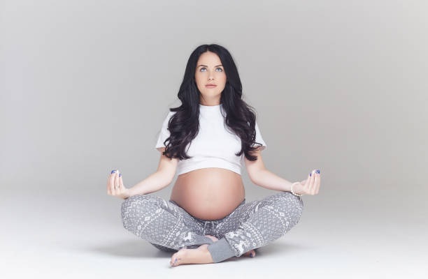 istock Pregnant brunette woman sits on a floor. 960470332