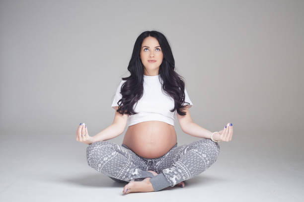 istock Pregnant brunette woman sits on a floor. 960470962