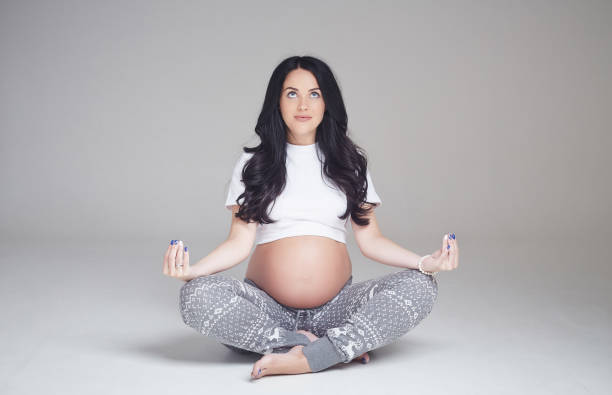 istock Pregnant brunette woman sits on a floor. 960471138