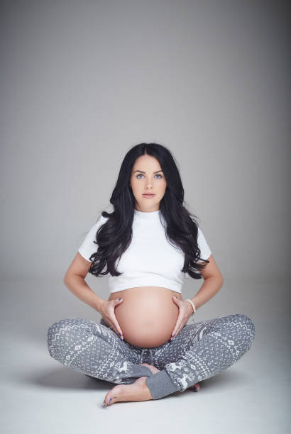 istock Pregnant brunette woman sits on a floor. 960471598