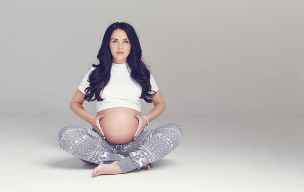 istock Pregnant brunette woman sits on a floor. 960472156
