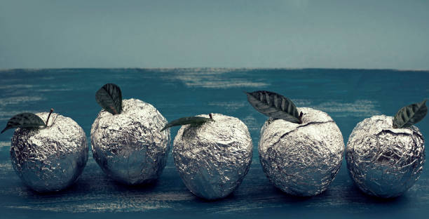 Banner Five apples in the shell foil with natural green leaves. Wooden candy blue background. Flat lay top view