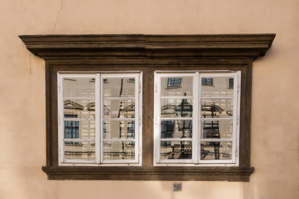 Old window reflecting a house and a street lamp. Hradcany, Prague, Czech republic.