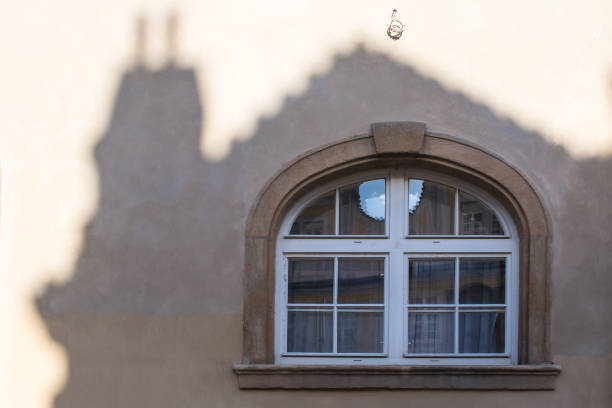 Old closed window with an arch. Lined by a shadow of another house. Mala strana, Prague, Czech republic