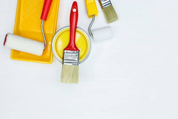 istock yellow paint tin, paint tray, rollers and paintbrushes on white 960492440