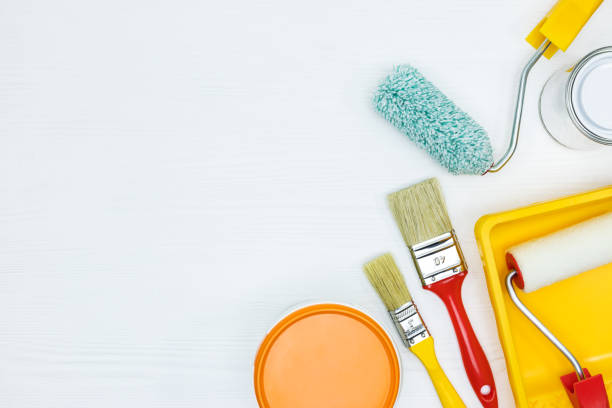istock tins with paint, brushes, rollers, paint track on white wooden surface 960492898