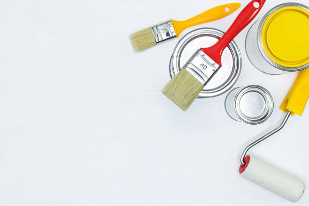 istock cans with paint, roller and paintbrushes on white wooden background 960493462