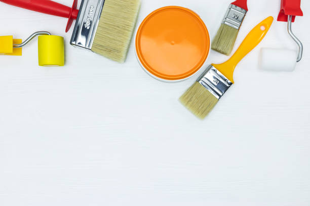 istock paint rollers and paintbrushes with can on white wooden background 960496900
