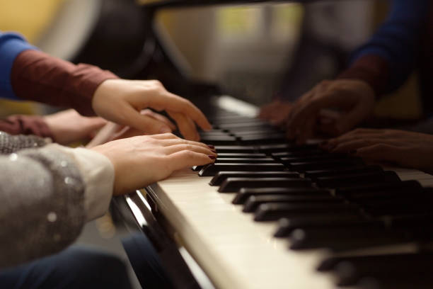 istock Two female playing the piano. 960498250