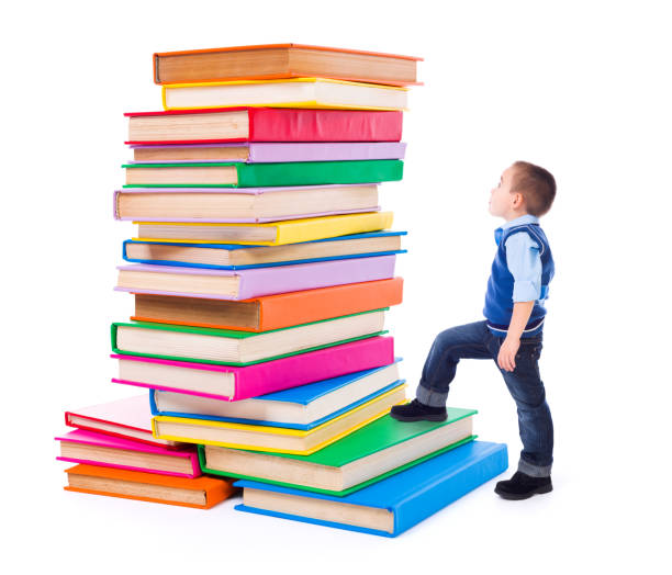 istock Little boy looking up to stacked big books 960505404