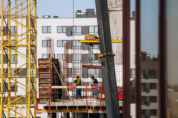 istock Workers engineers working at construction site and cranes on background of new building skyscrapers. Industrial landscape with building steel and concrete. worker engineer looking at development 960512480