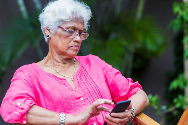 istock Elderly woman using her smartphone from her home's garden 960516068