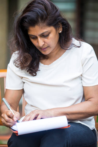 istock Young woman completing some financial documents 960516186