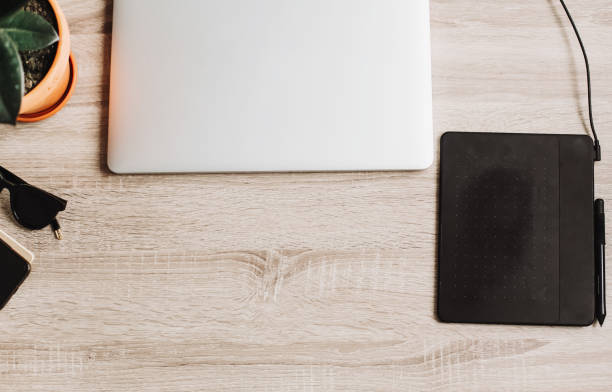 istock Freelance workplace concept flat lay for working with laptop, graphic tablet,notebook, glasses. illustration business. Designer office desk and IT gadgets. wooden table and office supplies top view 960516480