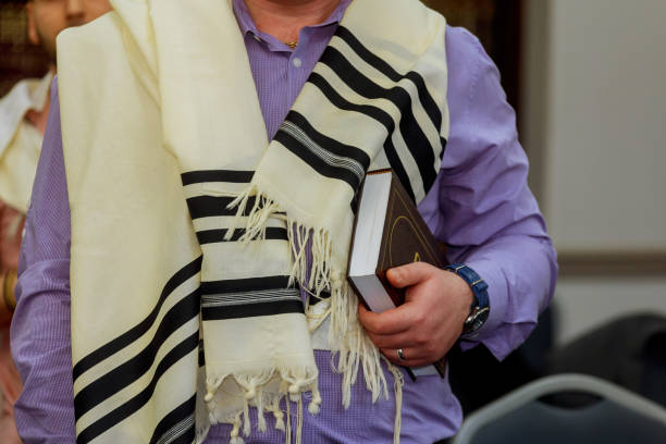 hände halten ein jüdisches gebetbuch tragen einen gebetsschal - judaism jewish ethnicity hasidism rabbi stock-fotos und bilder