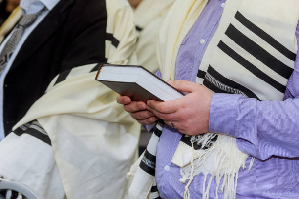 hände halten ein jüdisches gebetbuch tragen einen gebetsschal - judaism jewish ethnicity hasidism rabbi stock-fotos und bilder