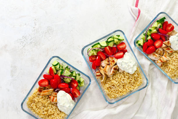 Greek chicken with tzatziki prepared and ready to eat in a take away lunch boxes Greek style grilled chicken breasts with tzatziki and freshly diced vegetables prepared and ready to eat in a take away lunch boxes, view from above, space for a text box container stock pictures, royalty-free photos & images