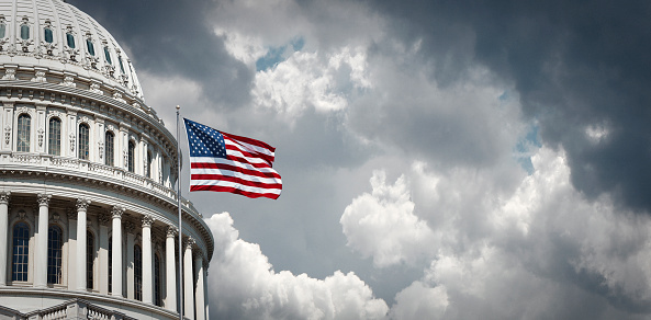 Capitolio de Estados Unidos y la bandera americana que agita photo