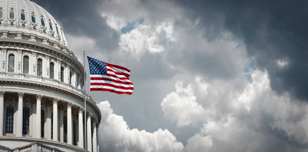 капитолий сша и развевающийся американский флаг - washington dc capitol building american flag sky стоковые фото и изображения