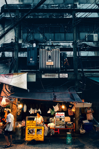 Bangkok, Thailand - August 17, 2018: A cook is preparing food in a restaurants on the street at Chinatown Bangkok. This area is very popular because the diverse food stands that appear at night time.