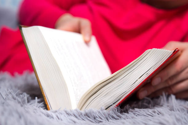 istock Close-up opened book in hands on woman. 960547734