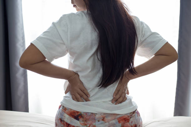 istock Woman with backache Sitting on the bed 960547948