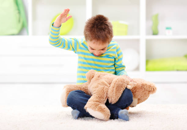 Domestic Abuse Angry little boy beating his teddy bear - domestic abuse concept aggresion in kids stock pictures, royalty-free photos & images