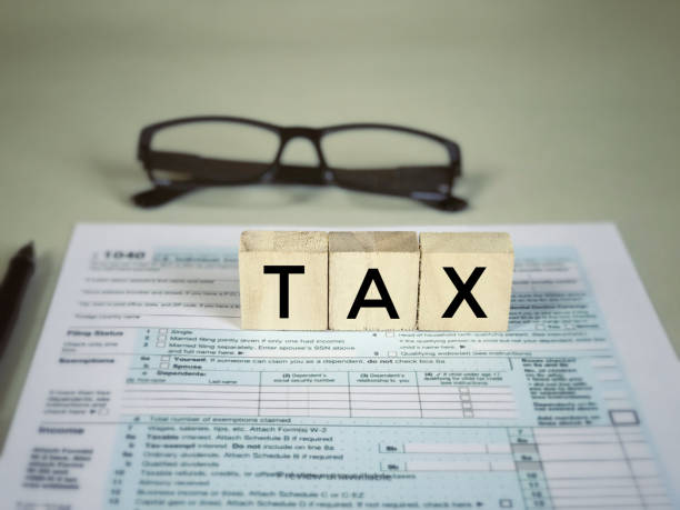 Business and finance concept. ‘Tax’ written on wooden blocks on US tax form. section 125 tax stock pictures, royalty-free photos  images