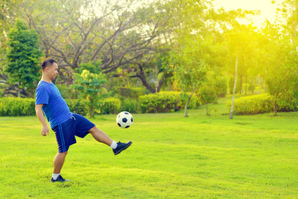 istock Asian fat man with football 960564358
