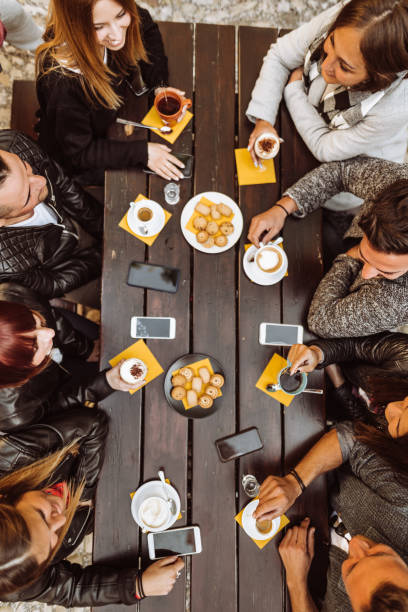 friends talking together on a cafe with smartphones , high angle view