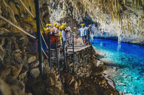 Inside the grotto of Lagoa Azul, a group of tourists Bonito, Brazil - November 19, 2017: Inside the grotto of Lagoa Azul, a group of tourists visiting the grotto, a famous touristic attraction of the city of Bonito. bonito brazil stock pictures, royalty-free photos & images