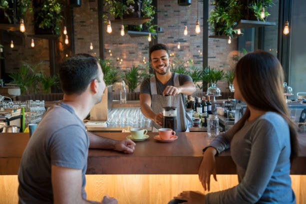 istock Waiter serving coffee to a couple at a cafe 960567904