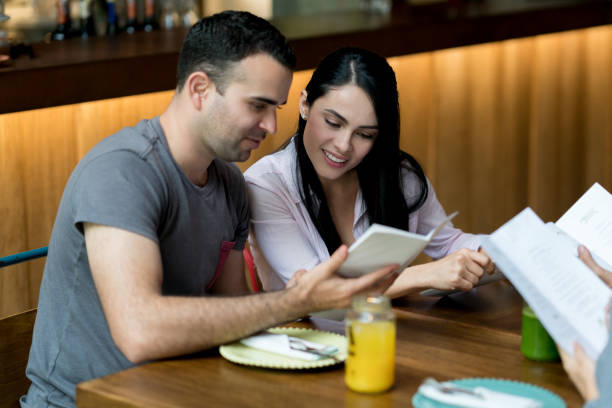 istock Happy couple at a restaurant looking at the menu 960567964