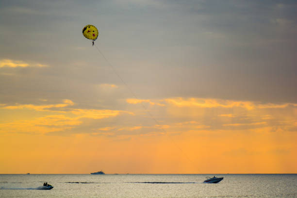istock People parasailing over the sea with sunset 960571474